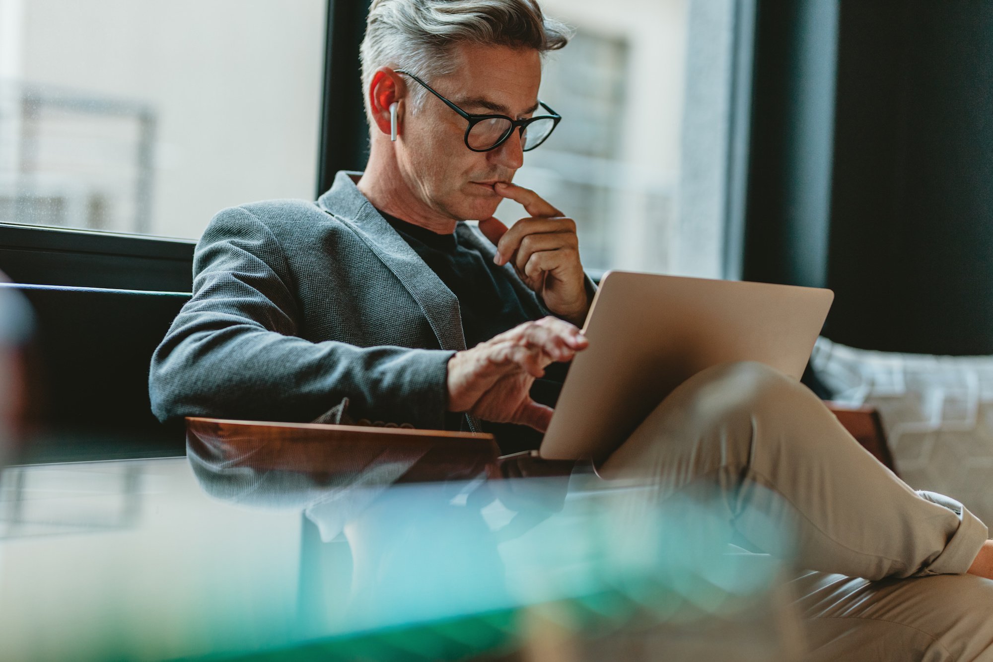 A white male working on his laptop as he puts together a justification for new technology for his boss to approve