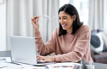 A female EA working on her laptop using TROOP's email template to ask her boss for new technology